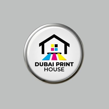 C ircular button featuring the logo of "Dubai Print House" with a stylized house icon and CMYK color stripes (cyan, magenta, yellow, and black) symbolizing printing beneath the house. The text "DUBAI PRINT HOUSE" is written below the graphic.